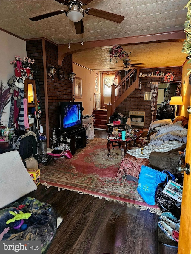 living room featuring hardwood / wood-style floors, ceiling fan, and a brick fireplace