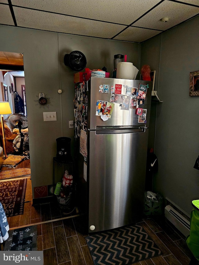 kitchen featuring a paneled ceiling, a baseboard radiator, and stainless steel refrigerator