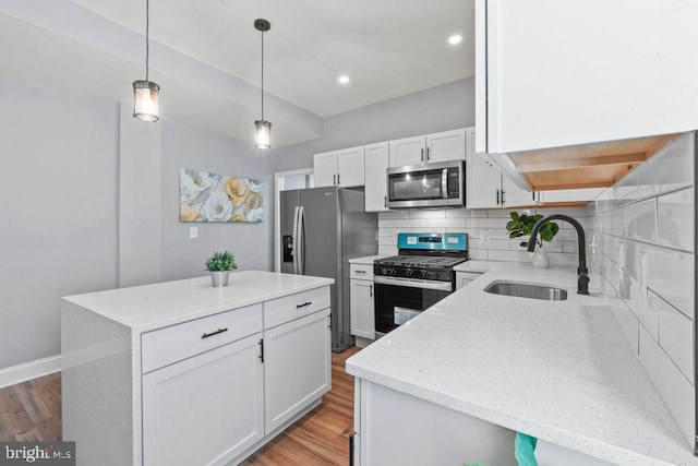 kitchen featuring sink, a kitchen island, tasteful backsplash, white cabinets, and appliances with stainless steel finishes