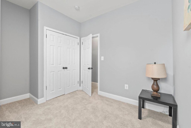 bedroom with light carpet and a closet