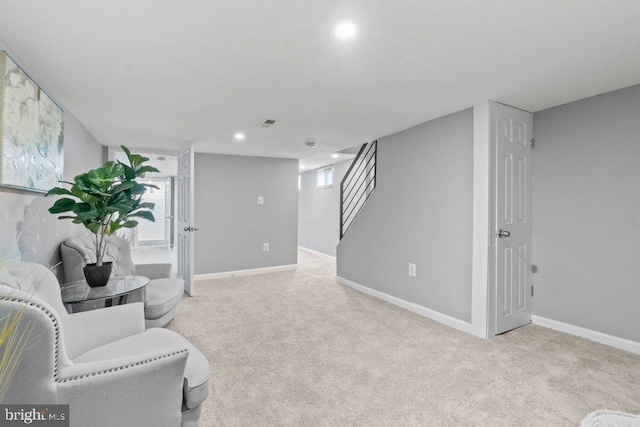 living area featuring light carpet