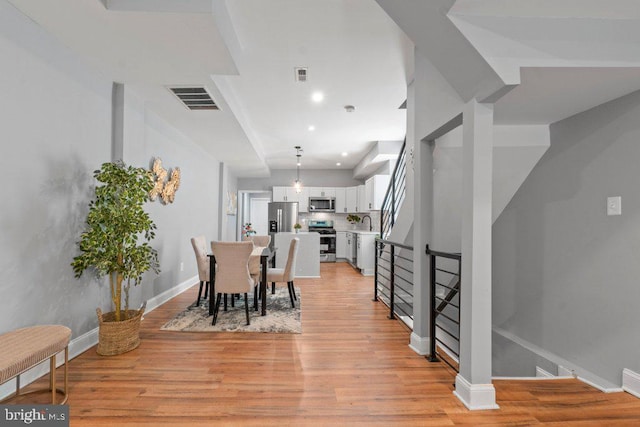 dining area featuring light wood-type flooring and sink