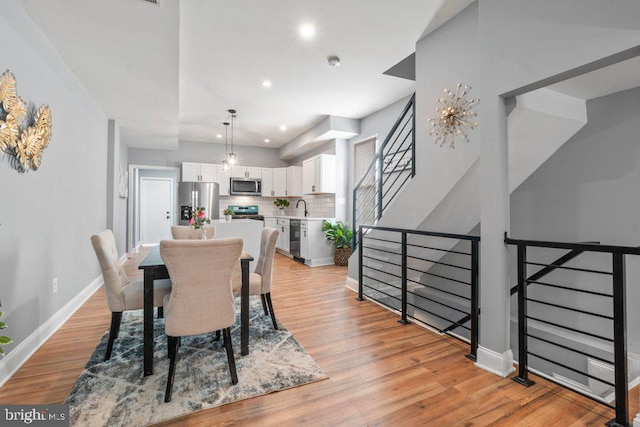 dining space with light hardwood / wood-style floors and sink