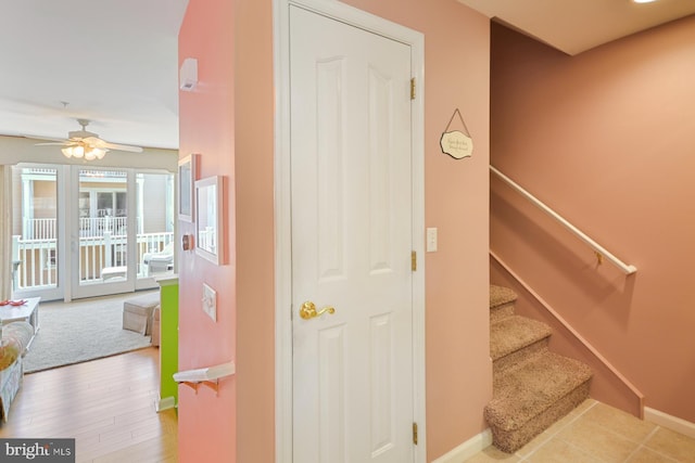 stairway with hardwood / wood-style flooring and ceiling fan