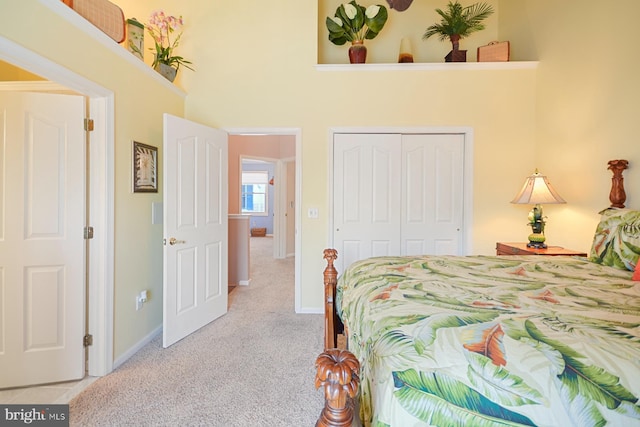 bedroom with light colored carpet, a closet, and a towering ceiling