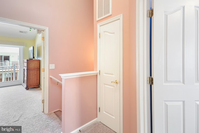 hall featuring light colored carpet