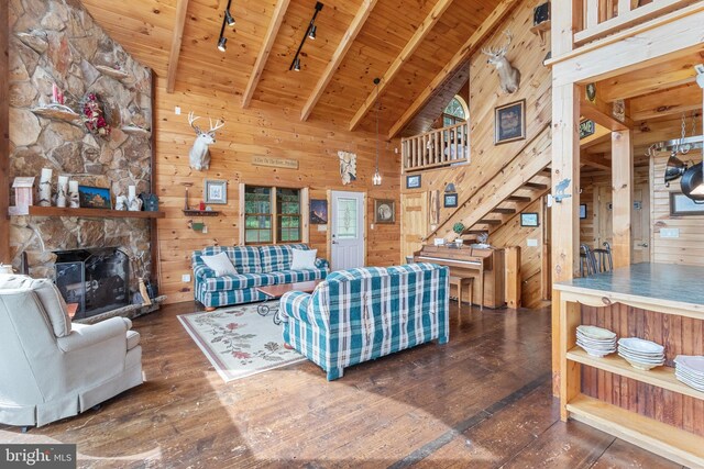 living room featuring dark wood-type flooring, a fireplace, wooden walls, and wood ceiling