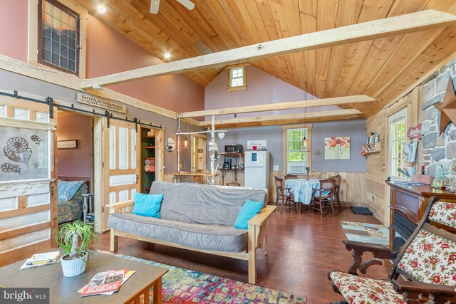 living room featuring a wealth of natural light, ceiling fan, wood-type flooring, and a barn door