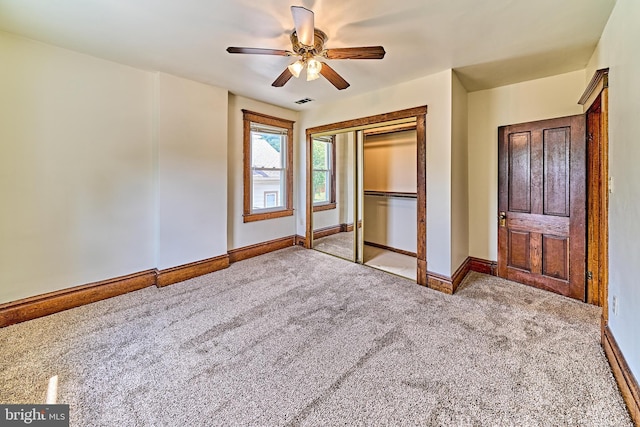 unfurnished bedroom featuring ceiling fan, a closet, and light colored carpet