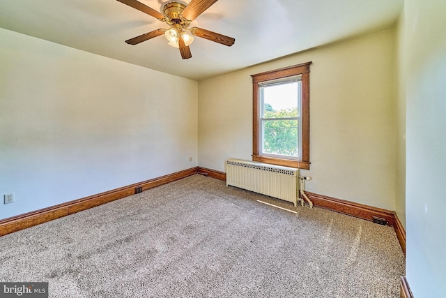 carpeted spare room with radiator, ceiling fan, and baseboards