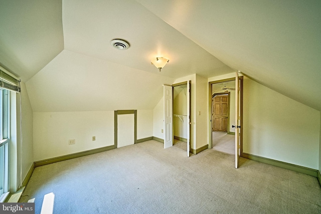 bonus room featuring carpet floors, baseboards, visible vents, and lofted ceiling