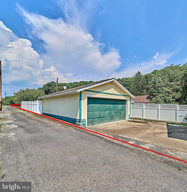 detached garage featuring fence