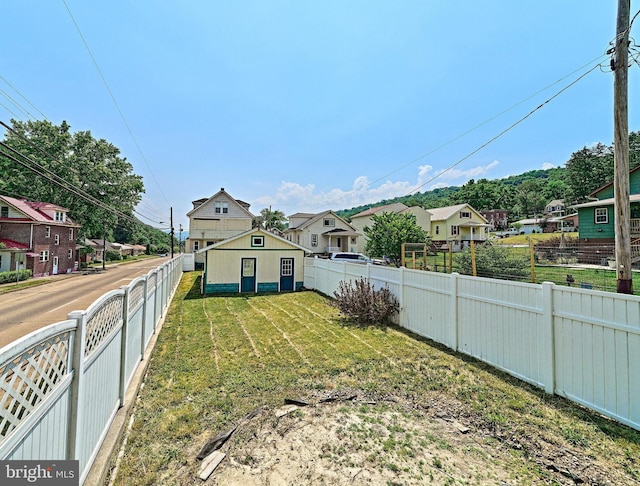 view of yard featuring a fenced backyard and a residential view