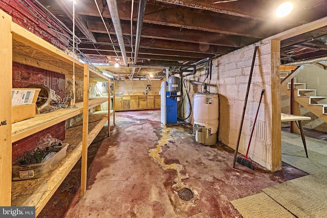 unfinished below grade area featuring water heater and stairway