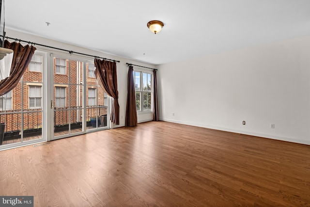 unfurnished room with baseboards, visible vents, and wood finished floors