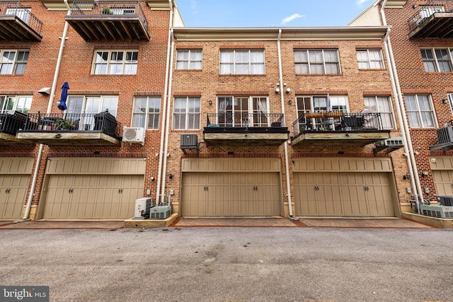 rear view of house featuring cooling unit, brick siding, central AC, and ac unit