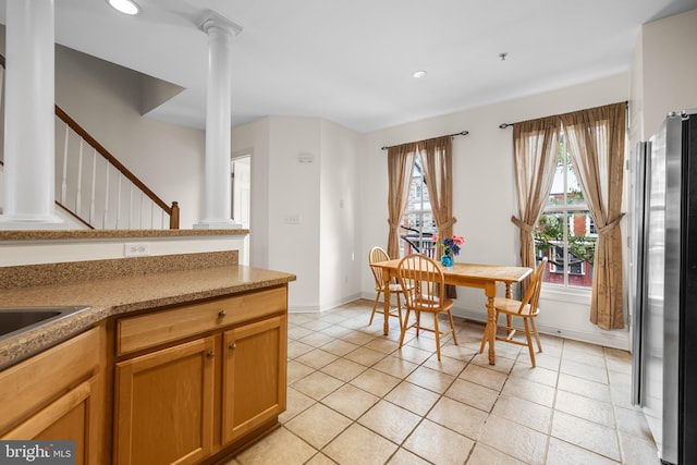 dining room with light tile patterned floors, recessed lighting, baseboards, stairway, and ornate columns