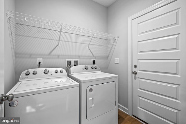 clothes washing area with dark hardwood / wood-style flooring and washing machine and clothes dryer