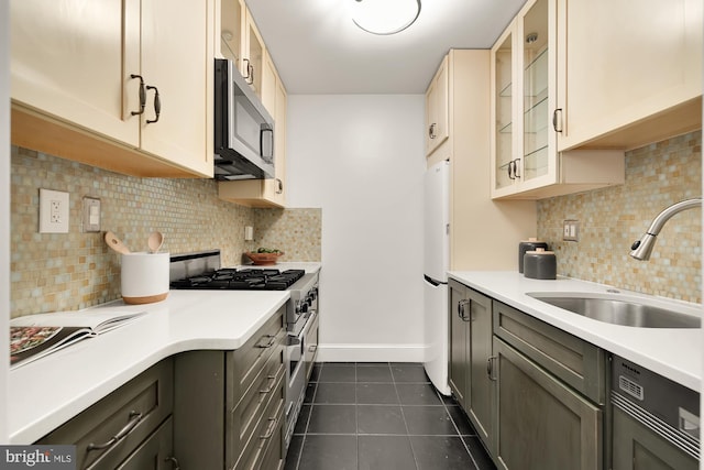 kitchen featuring sink, gray cabinets, dark tile patterned floors, appliances with stainless steel finishes, and tasteful backsplash