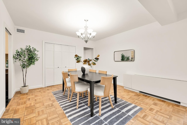 dining area with light parquet flooring and a chandelier