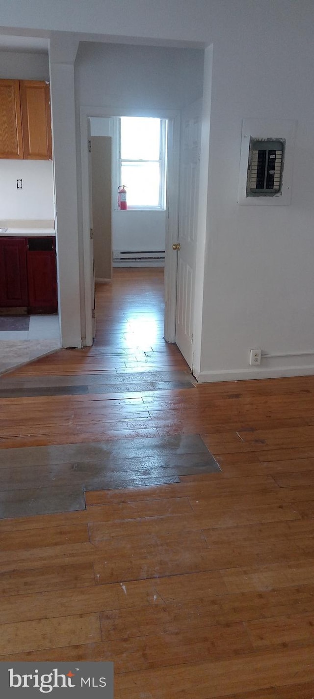 hallway featuring a baseboard radiator and hardwood / wood-style flooring