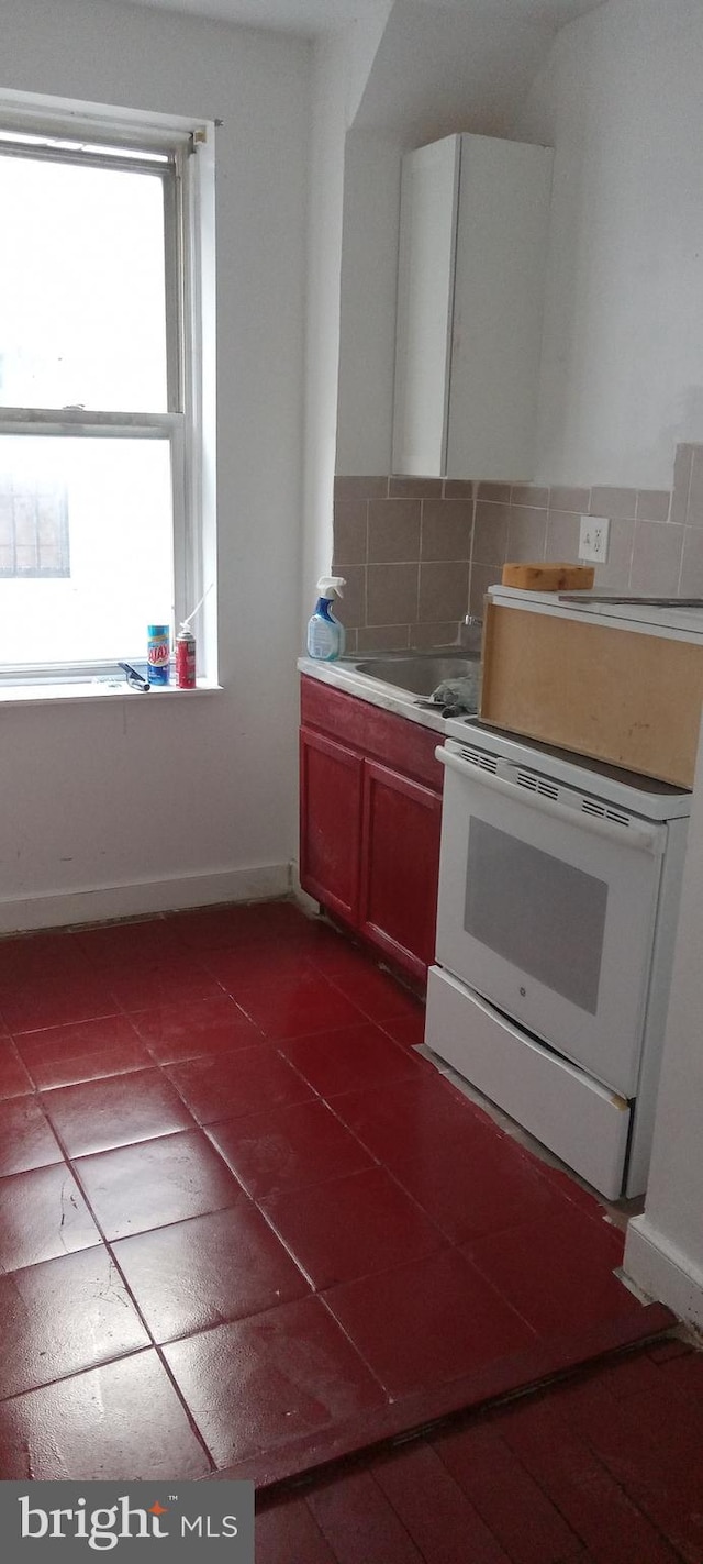 kitchen with backsplash, tile patterned flooring, and white electric range oven