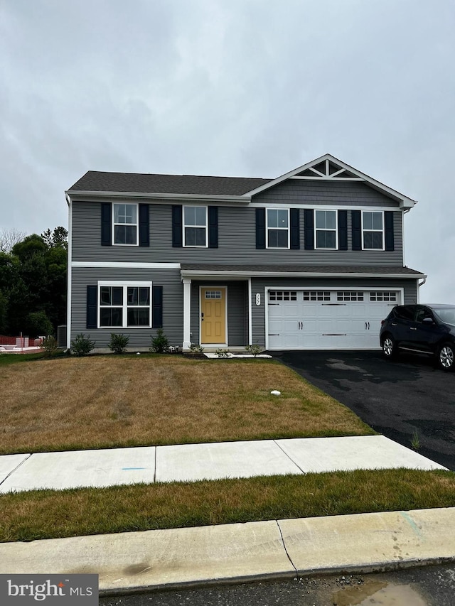 view of front of home featuring a front yard and a garage