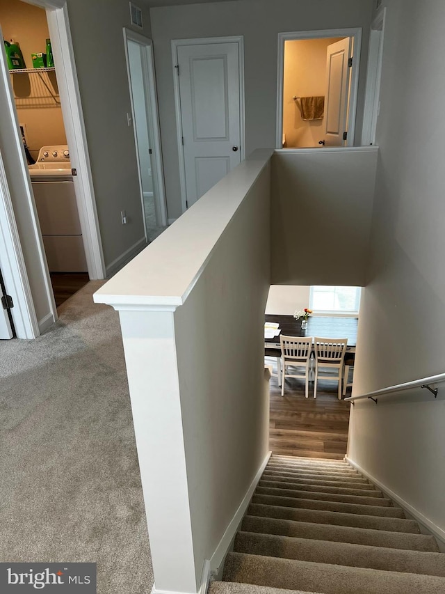 staircase with carpet flooring and washer / clothes dryer