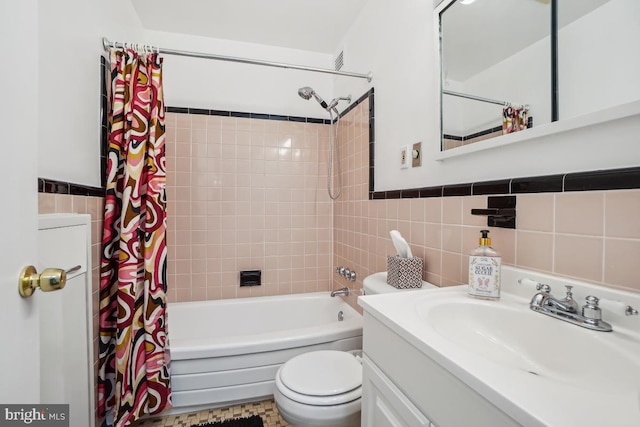 full bathroom with vanity, toilet, tile walls, and shower / tub combo with curtain