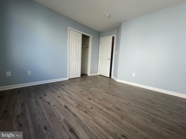 unfurnished bedroom featuring dark hardwood / wood-style floors and a closet