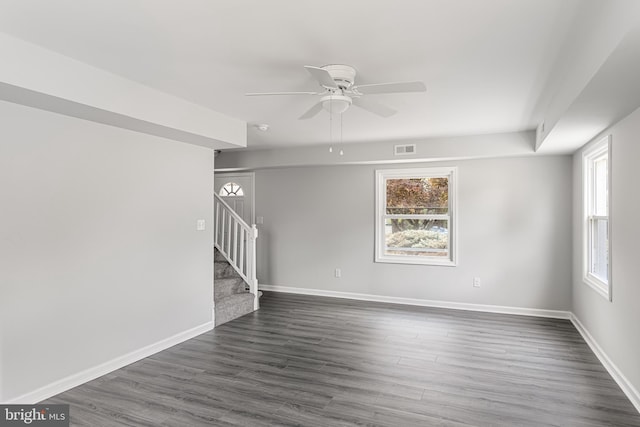 spare room with a wealth of natural light, ceiling fan, and dark hardwood / wood-style floors