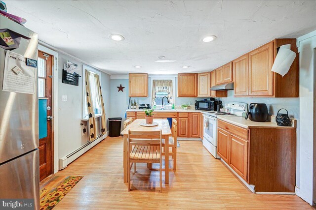 kitchen with electric stove, sink, baseboard heating, light hardwood / wood-style floors, and stainless steel refrigerator