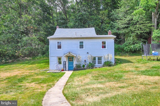 colonial home with a front lawn and a trampoline