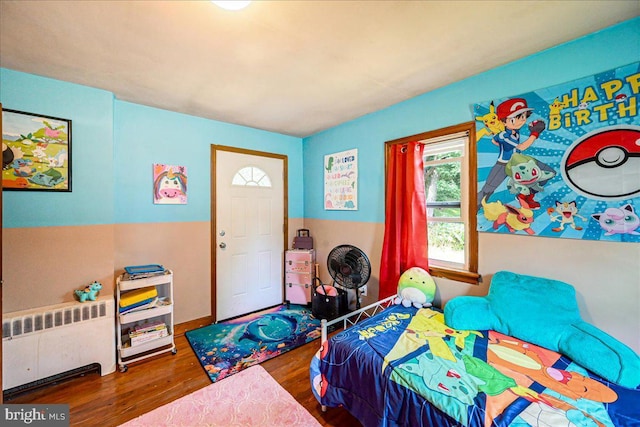 bedroom featuring radiator heating unit and dark wood-type flooring