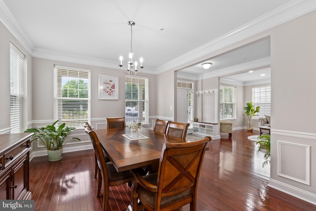 dining area with ornamental molding, dark wood-style flooring, wainscoting, and an inviting chandelier