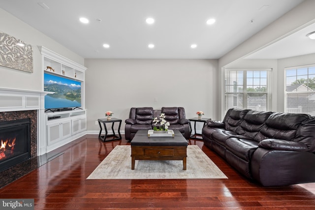 living area with a premium fireplace, dark wood finished floors, and recessed lighting