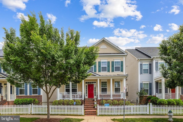 view of front of house with a fenced front yard, covered porch, and brick siding