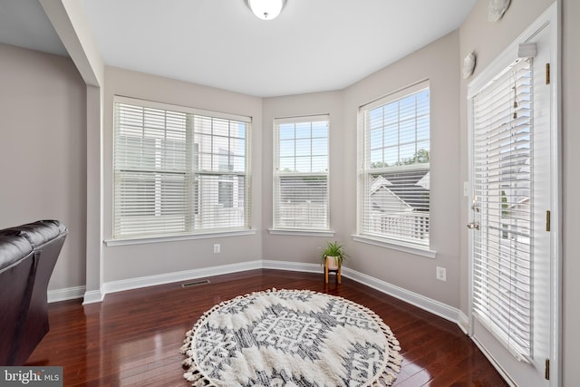 sitting room featuring dark wood-style floors, visible vents, and baseboards