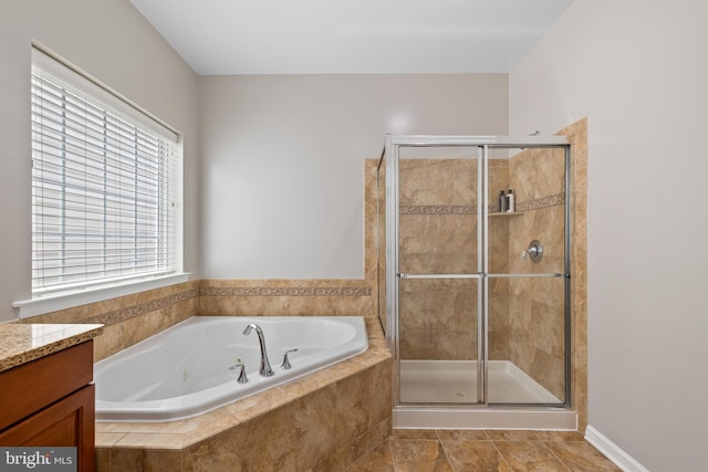 bathroom with a tub with jets, a stall shower, and vanity