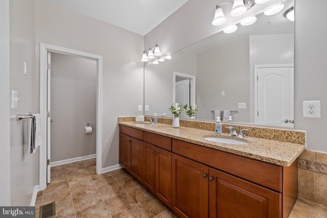 bathroom featuring visible vents, a sink, and double vanity