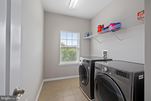 laundry area with laundry area, washer and clothes dryer, baseboards, and light tile patterned floors