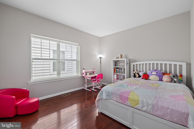 bedroom with dark wood finished floors, visible vents, and baseboards