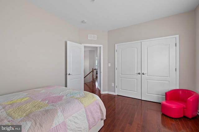 bedroom featuring dark wood-style floors, a closet, visible vents, and baseboards