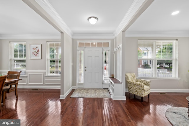 entryway with dark wood-style floors, wainscoting, ornamental molding, and baseboards