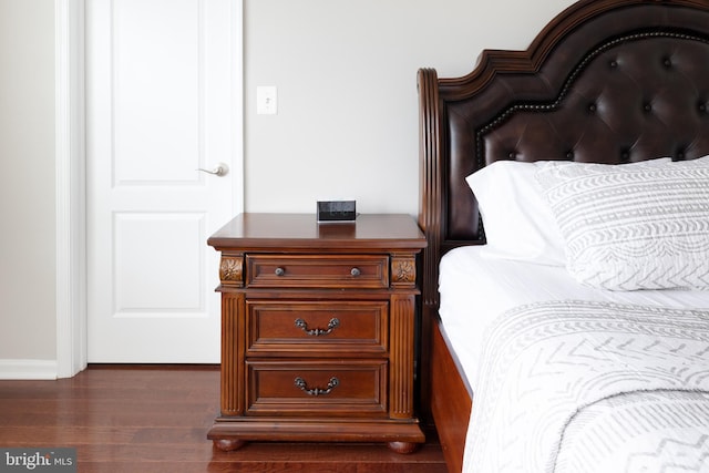 bedroom with dark wood-style flooring