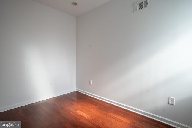 empty room with dark hardwood / wood-style flooring