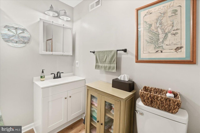 bathroom featuring vanity, toilet, and wood-type flooring