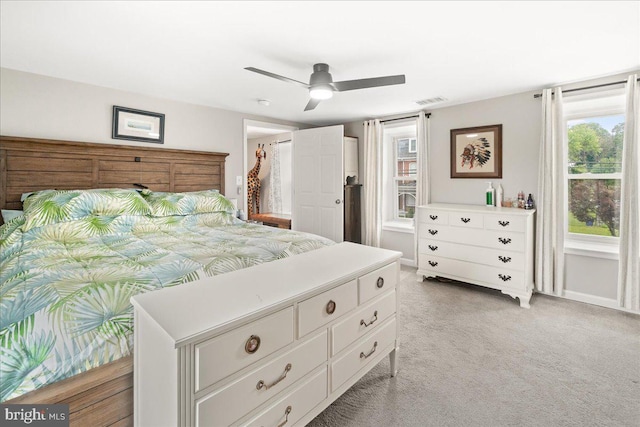 carpeted bedroom with ceiling fan and multiple windows