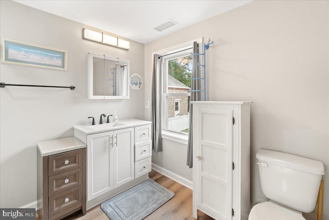 bathroom featuring vanity, hardwood / wood-style floors, and toilet