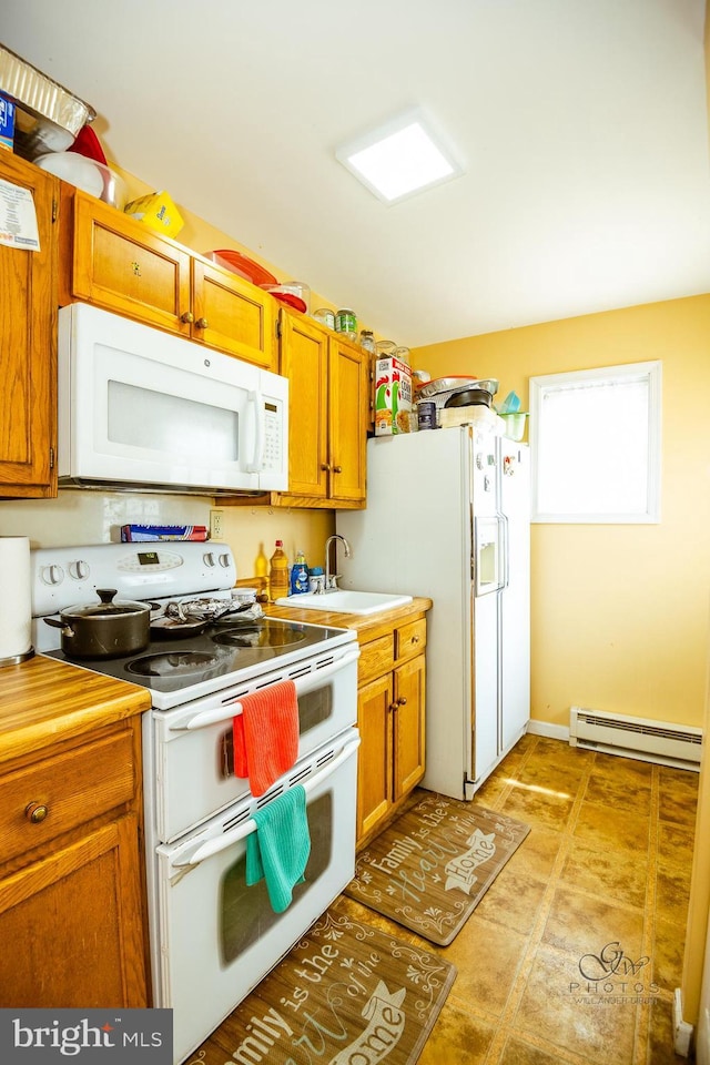 kitchen with sink, a baseboard radiator, and white appliances